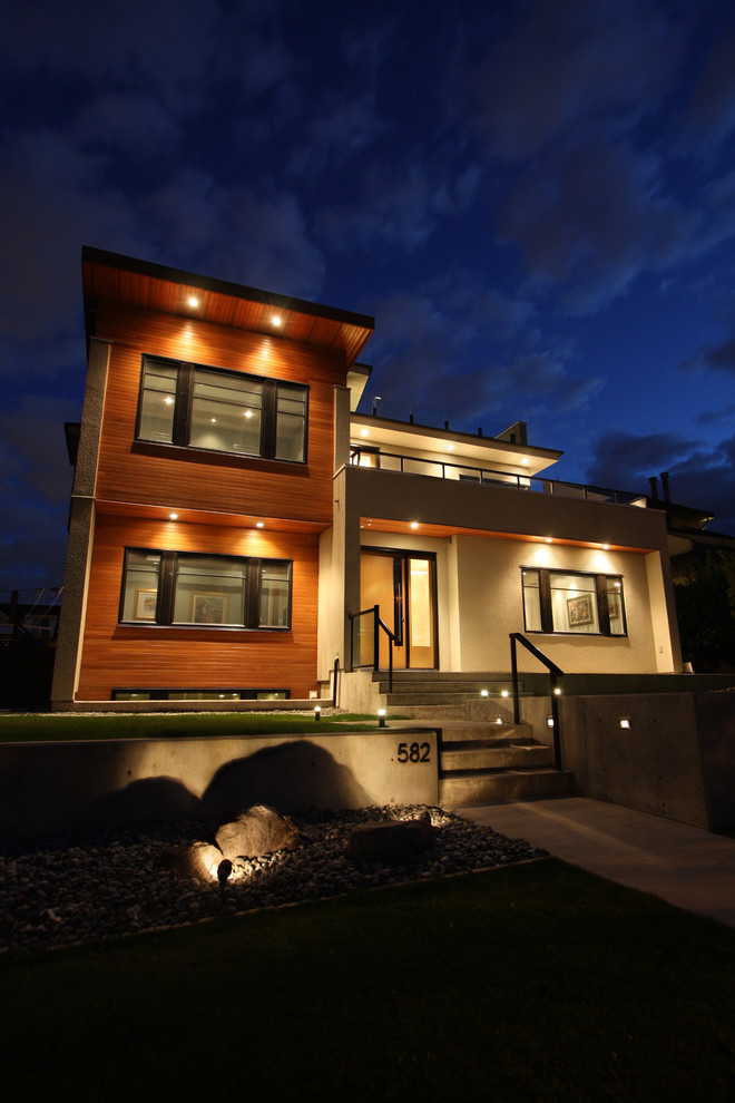 Medium sized and beige contemporary two floor detached house in Vancouver with mixed cladding and a flat roof.