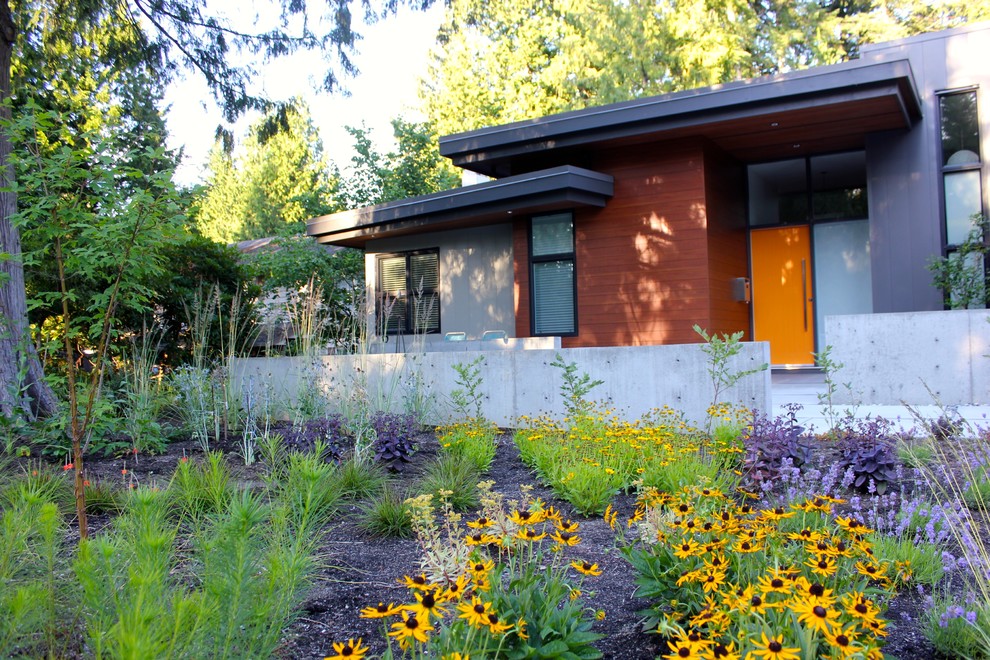 Réalisation d'une façade de maison grise design avec un revêtement mixte.