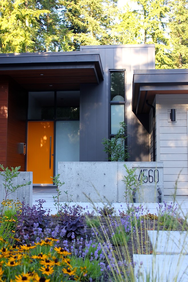Cette photo montre une façade de maison grise tendance avec un revêtement mixte.