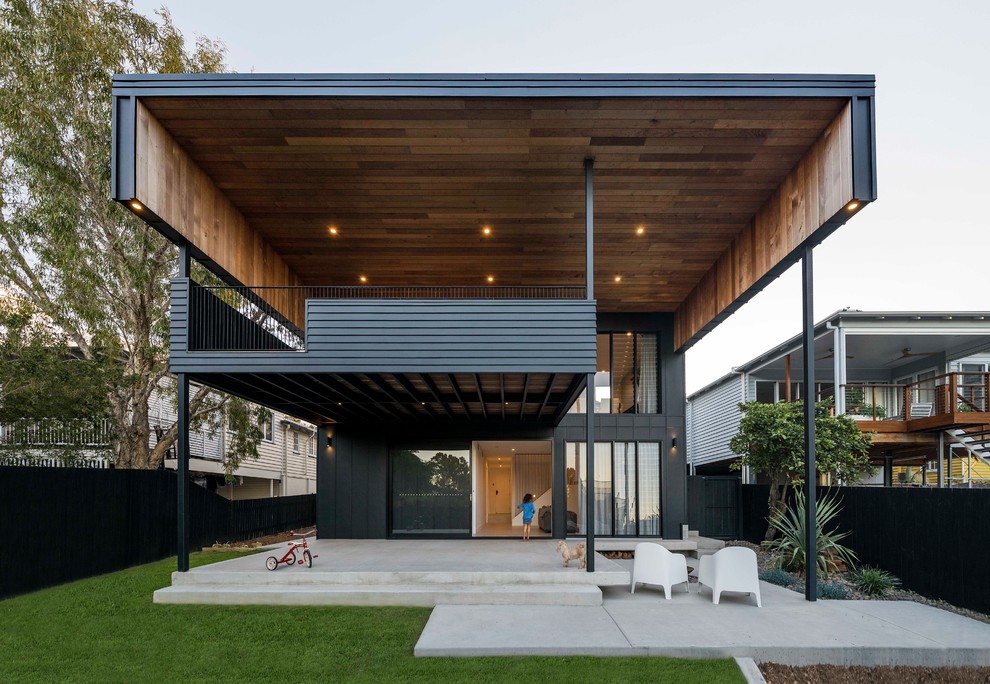 Diseño de fachada de casa negra contemporánea de dos plantas con revestimiento de aglomerado de cemento y tejado plano