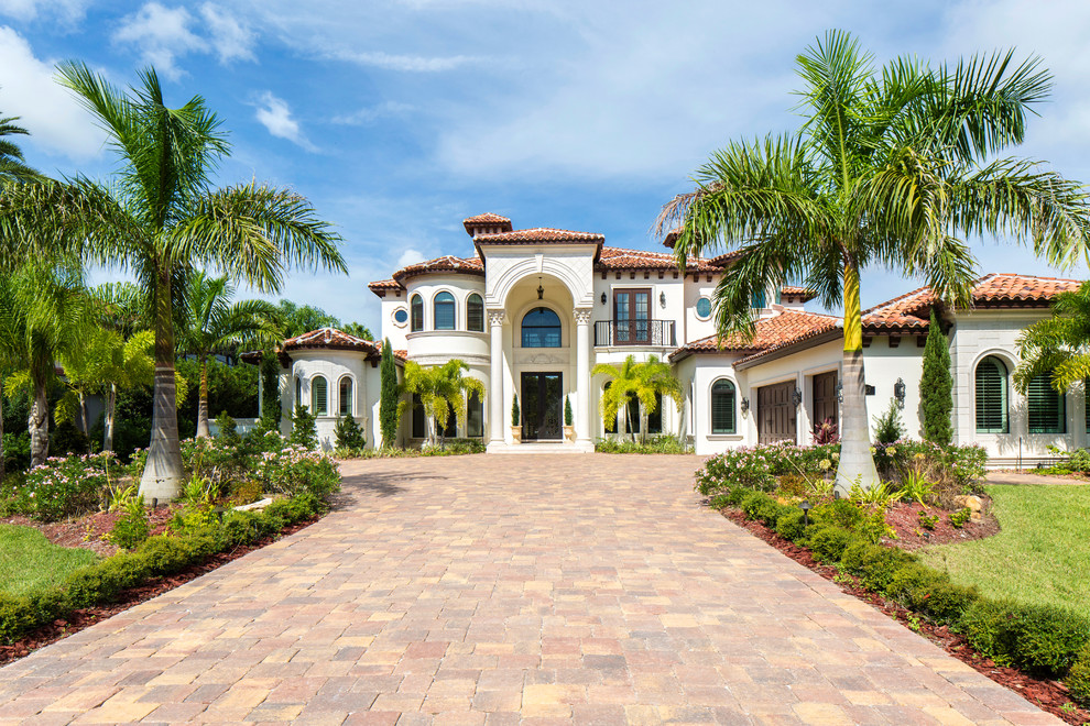 Zweistöckiges Mediterranes Haus mit Putzfassade, weißer Fassadenfarbe und Walmdach in Orlando