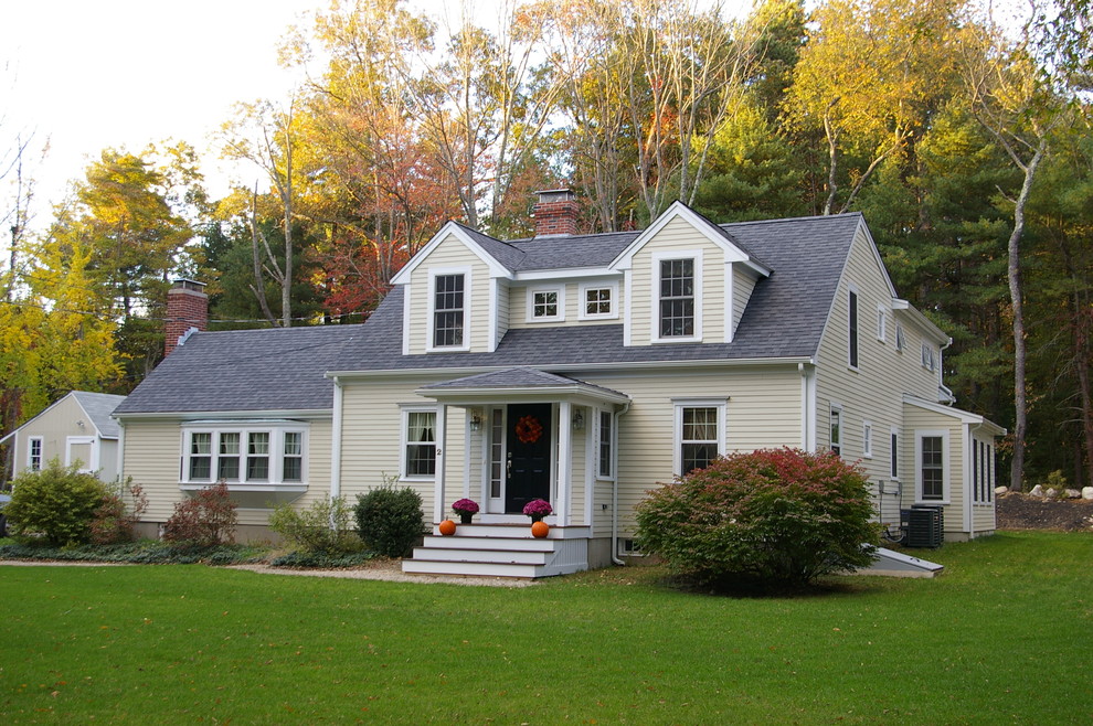 Aménagement d'une grande façade de maison beige classique en bois à un étage avec un toit à deux pans et un toit en shingle.
