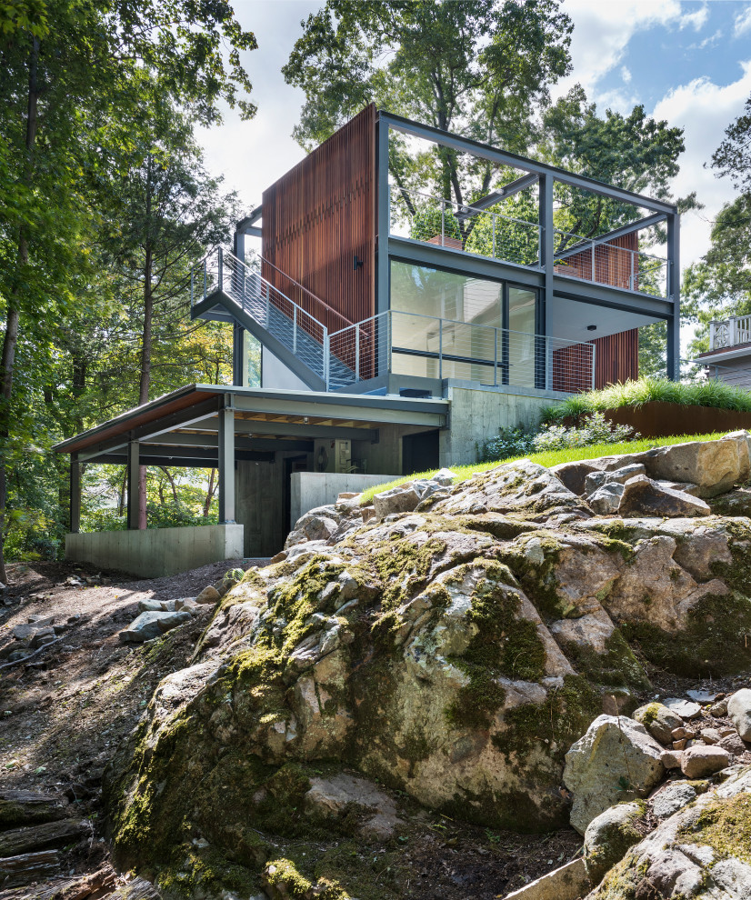 Exemple d'une petite façade de maison grise moderne en bois à deux étages et plus avec un toit en métal.