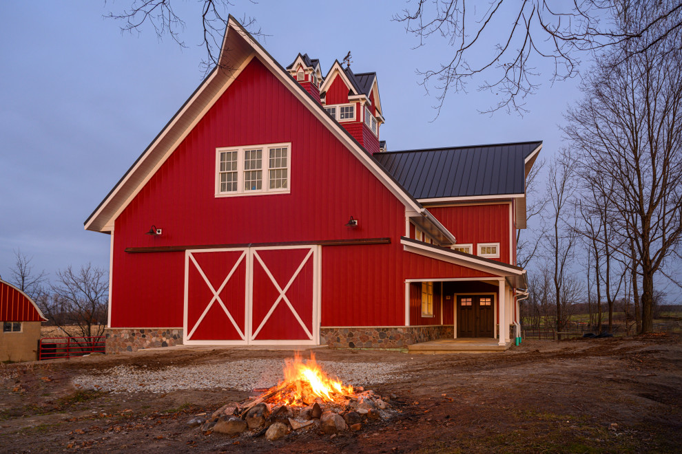 Пример оригинального дизайна: большой, трехэтажный, красный дом в классическом стиле с облицовкой из металла, двускатной крышей и металлической крышей