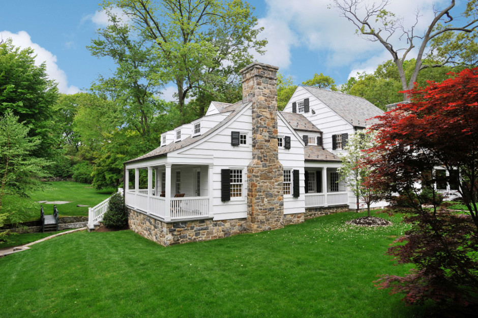 Cette photo montre une façade de maison blanche chic en bois de taille moyenne et à un étage avec un toit à deux pans.