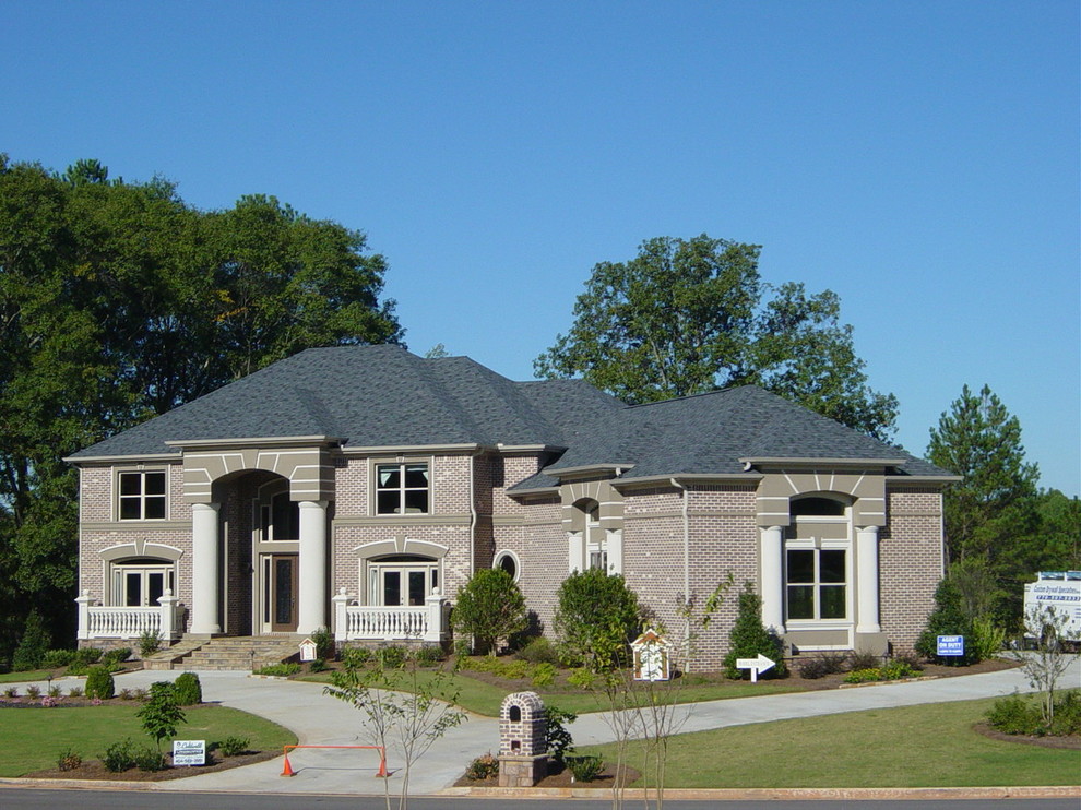 Idée de décoration pour une grande façade de maison rouge tradition en brique à un étage avec un toit à quatre pans.