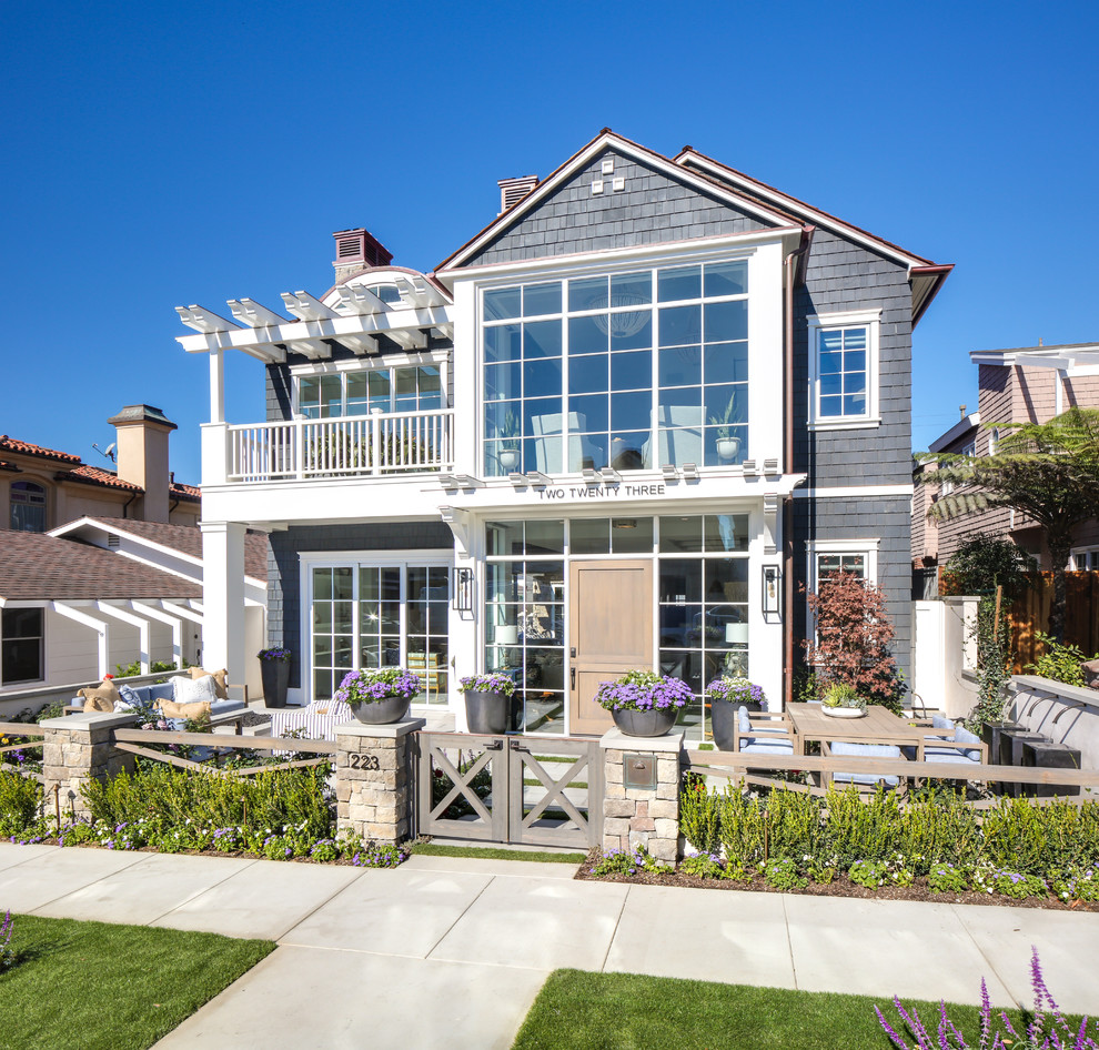 Example of a beach style gray two-story wood exterior home design in Orange County with a shingle roof