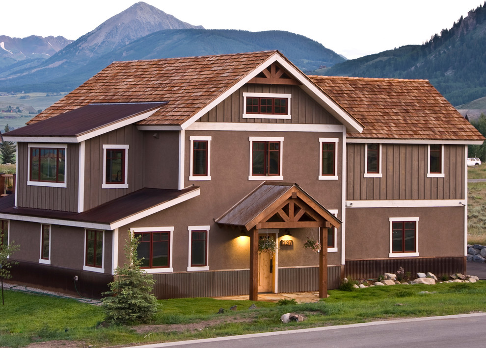 Aménagement d'une façade de maison marron montagne de taille moyenne et à un étage avec un revêtement mixte.