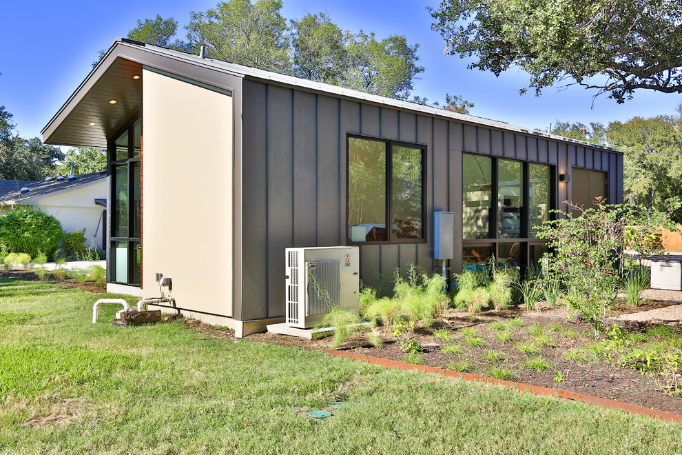 Пример оригинального дизайна: одноэтажный, серый дом среднего размера в современном стиле с комбинированной облицовкой и односкатной крышей