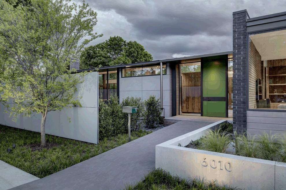 Inspiration for a huge modern gray two-story brick house exterior remodel in Dallas with a shed roof and a metal roof