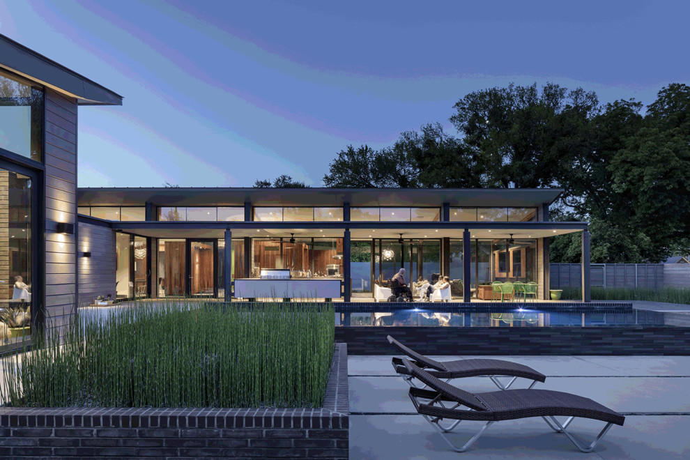 Huge modern gray two-story brick house exterior idea in Dallas with a shed roof and a metal roof