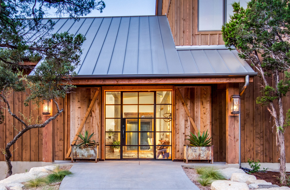 Mittelgroßes, Zweistöckiges Stilmix Haus mit brauner Fassadenfarbe und Blechdach in Austin