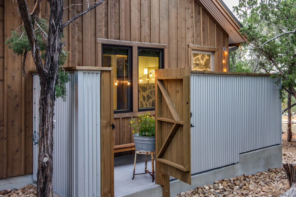 Aménagement d'une petite façade de maison marron éclectique en bois à un étage avec un toit à deux pans et un toit en métal.