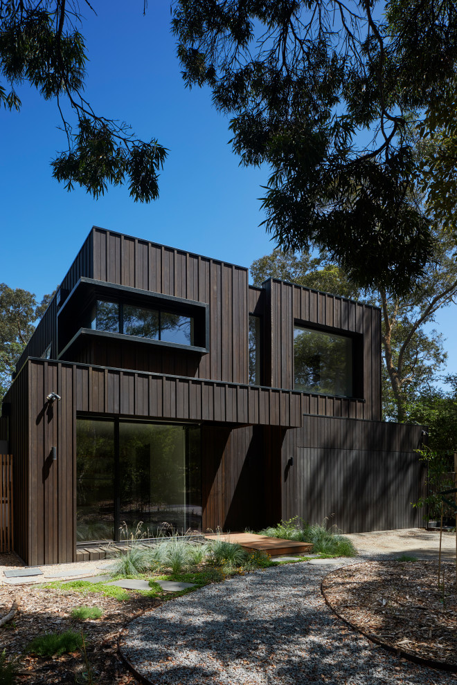 Inspiration för mellanstora moderna svarta hus, med två våningar, platt tak och tak i metall