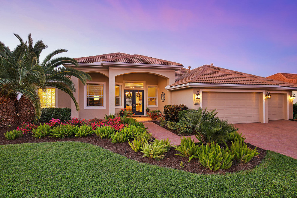 Mittelgroßes, Einstöckiges Mediterranes Einfamilienhaus mit Putzfassade, beiger Fassadenfarbe, Walmdach und Ziegeldach in Tampa