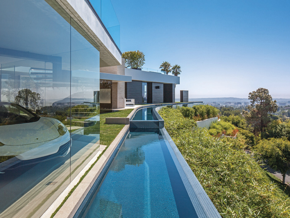 Beige contemporary glass house exterior in Los Angeles with three floors.