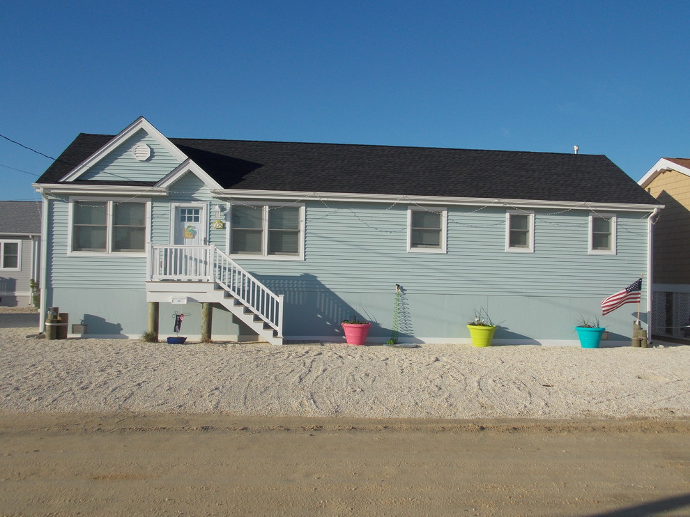 Photo of a blue beach style bungalow detached house in New York with vinyl cladding, a pitched roof and a shingle roof.