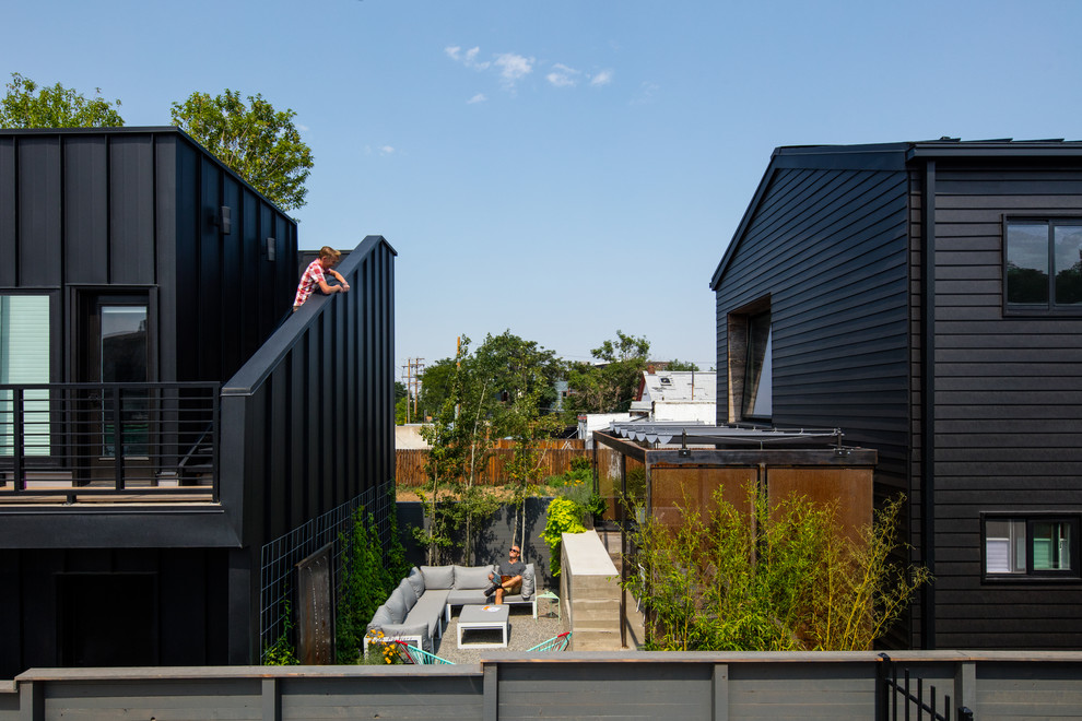 Ispirazione per la villa nera moderna a due piani di medie dimensioni con rivestimento in metallo, tetto a capanna e copertura in metallo o lamiera