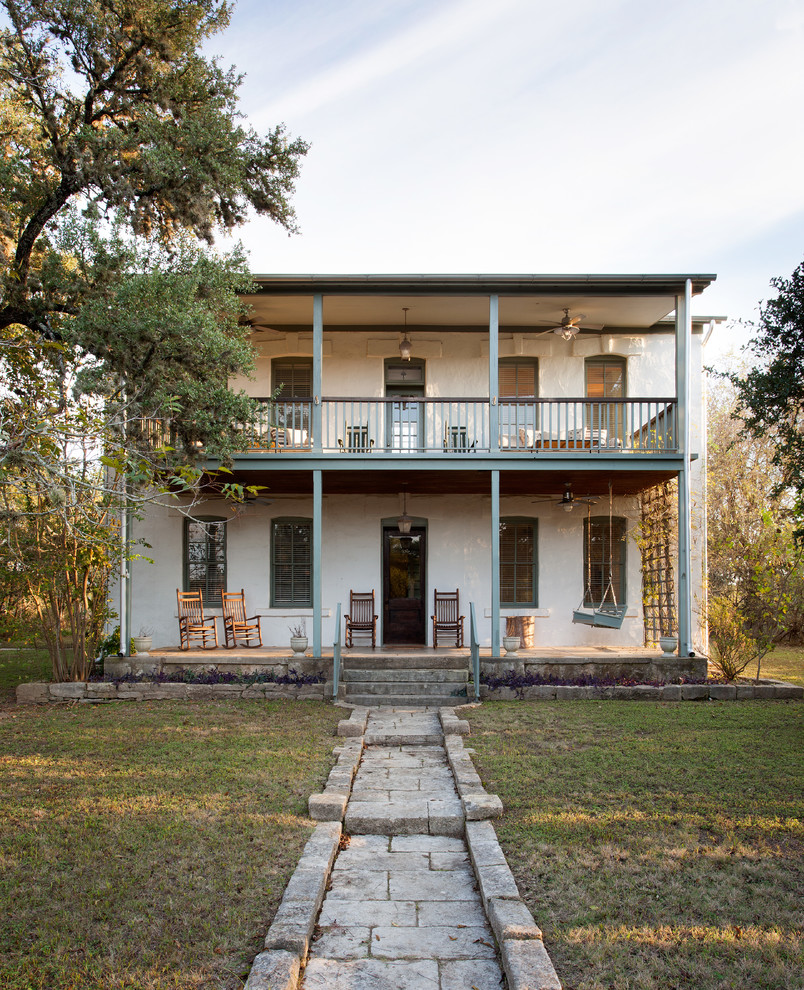 Zweistöckiges, Mittelgroßes Landhaus Einfamilienhaus mit Putzfassade, weißer Fassadenfarbe und Pultdach in Austin
