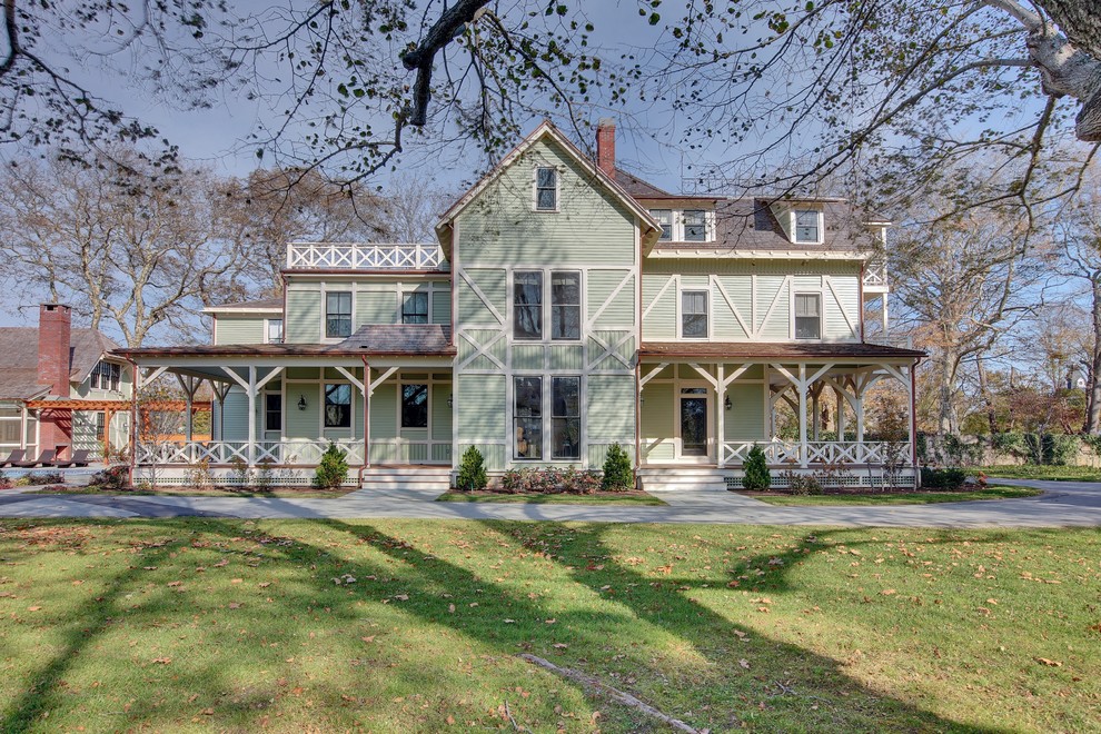 Стильный дизайн: трехэтажный, зеленый дом в классическом стиле с двускатной крышей - последний тренд