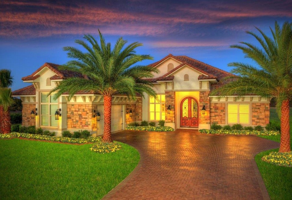 Mid-sized tropical beige one-story stone exterior home idea in Orlando