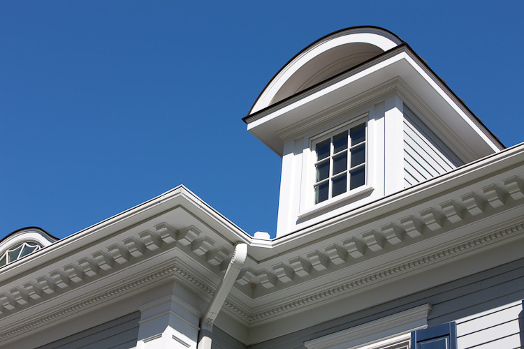 Cette image montre une façade de maison grise traditionnelle en panneau de béton fibré de taille moyenne et à un étage avec un toit à quatre pans et un toit en shingle.