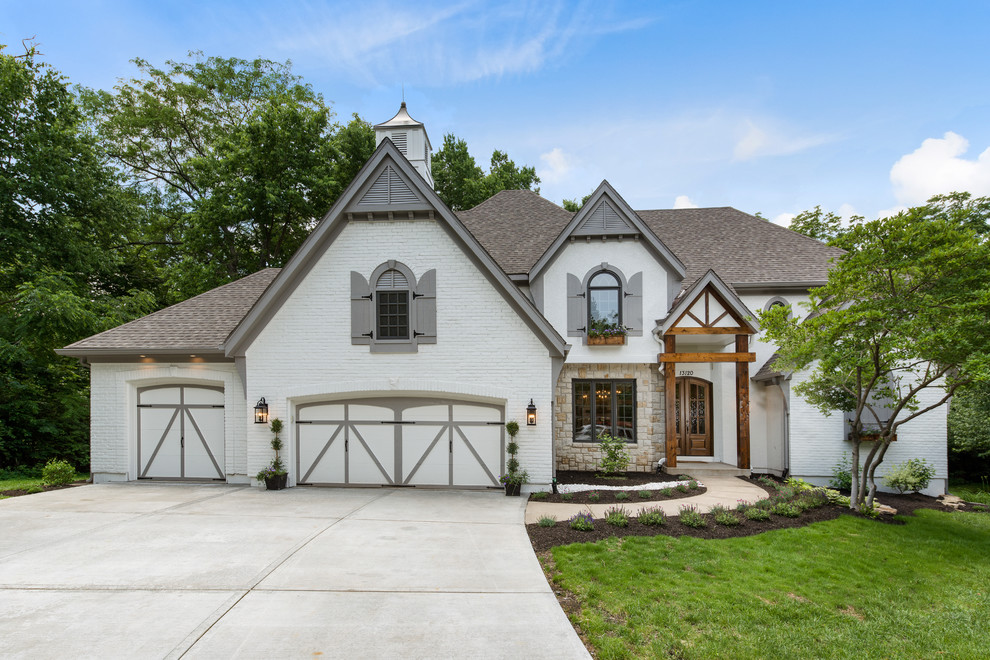 Large and white traditional two floor brick detached house in Kansas City with a shingle roof and a hip roof.