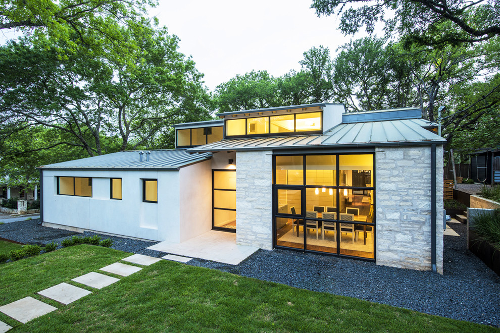 Aménagement d'une façade de maison grise contemporaine de taille moyenne et à un étage avec un revêtement mixte et un toit plat.