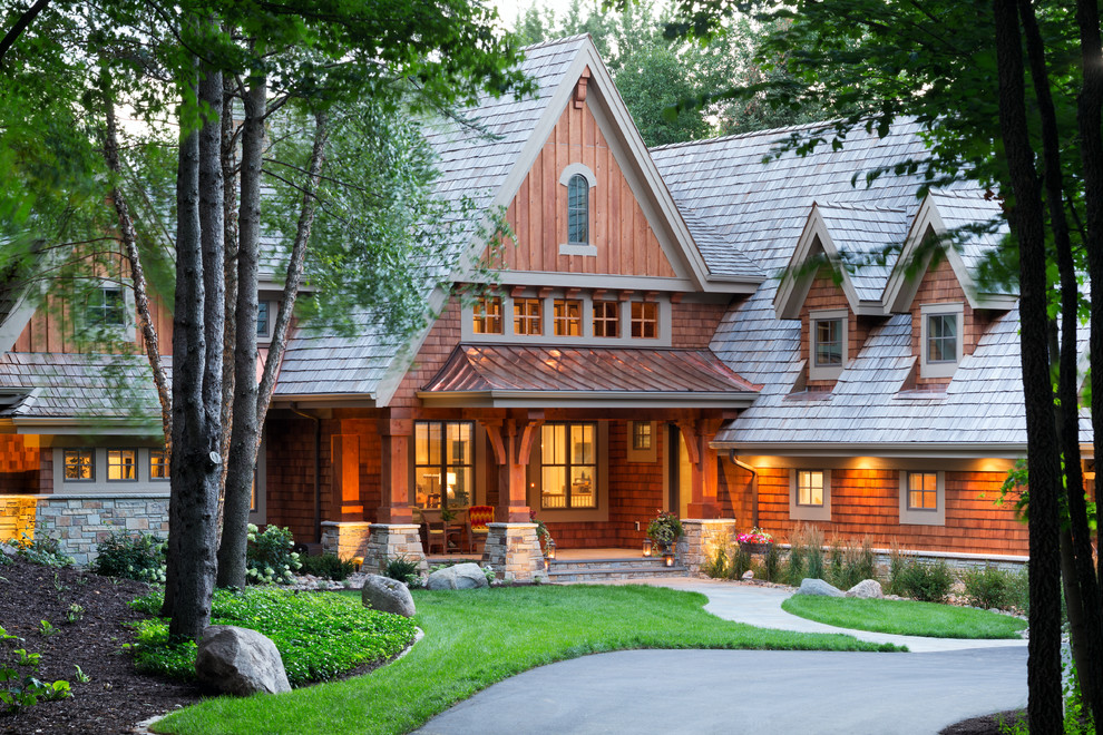Photo of an expansive and brown rustic house exterior in Minneapolis with wood cladding and a pitched roof.