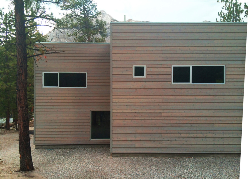 Пример оригинального дизайна: большой, двухэтажный, деревянный, коричневый дом в стиле модернизм с плоской крышей