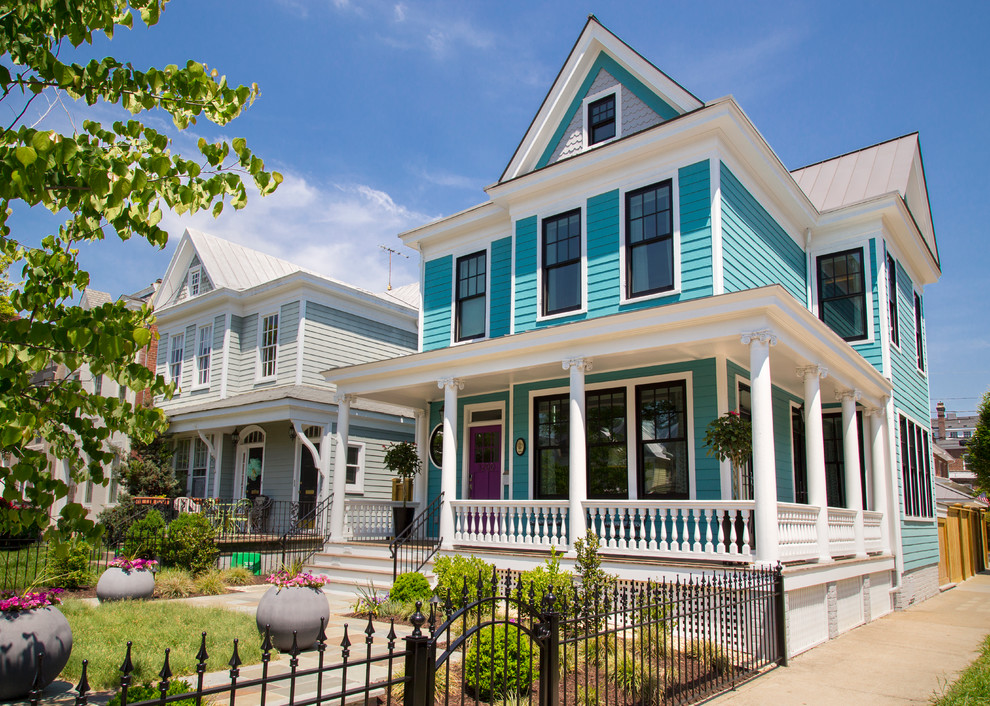 На фото: двухэтажный, деревянный, синий дом в классическом стиле с двускатной крышей