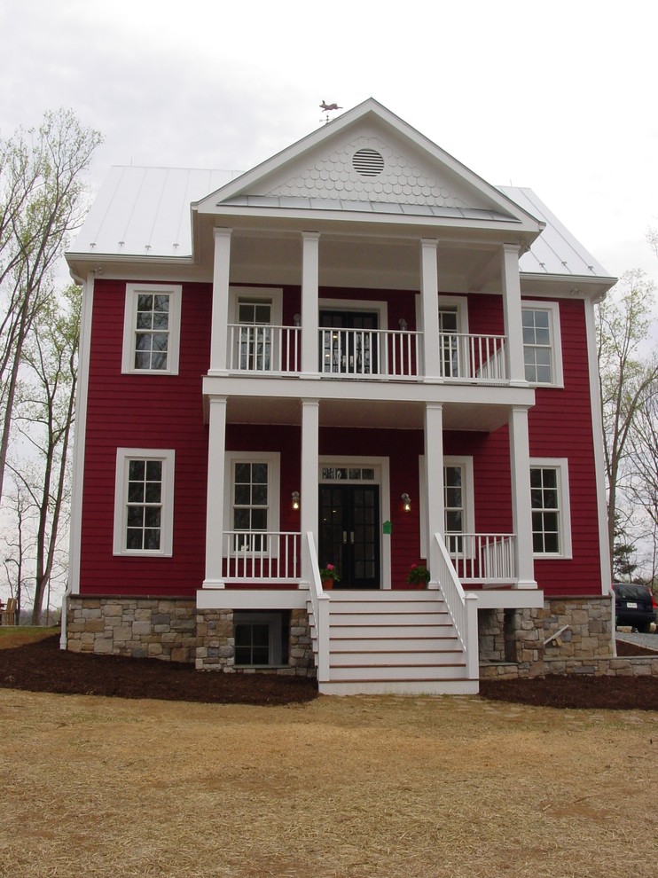 На фото: трехэтажный, красный, большой частный загородный дом в стиле кантри с облицовкой из ЦСП, двускатной крышей и металлической крышей