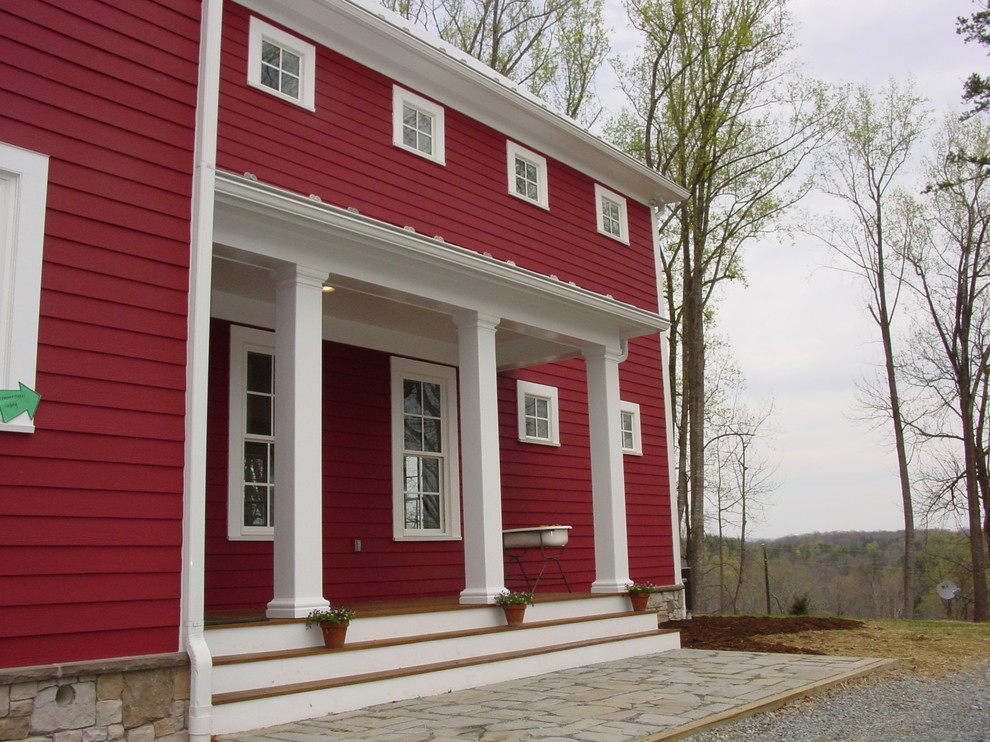 Exemple d'une grande façade de maison rouge nature en panneau de béton fibré à deux étages et plus avec un toit à deux pans et un toit en métal.