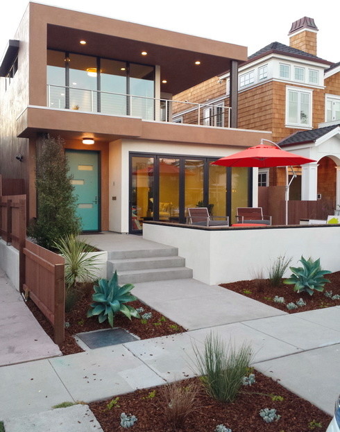Diseño de fachada beige moderna de dos plantas con revestimiento de estuco y tejado plano