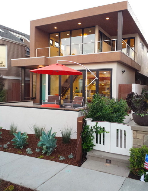Ejemplo de fachada beige minimalista de dos plantas con revestimiento de estuco y tejado plano