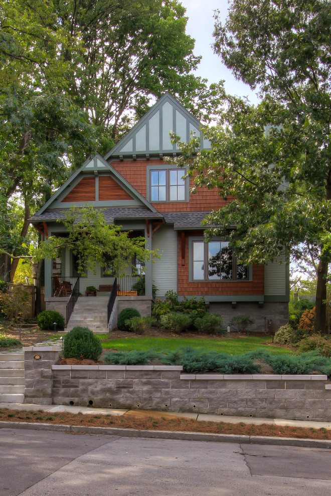 На фото: маленький, двухэтажный, синий дом в стиле кантри с двускатной крышей для на участке и в саду с