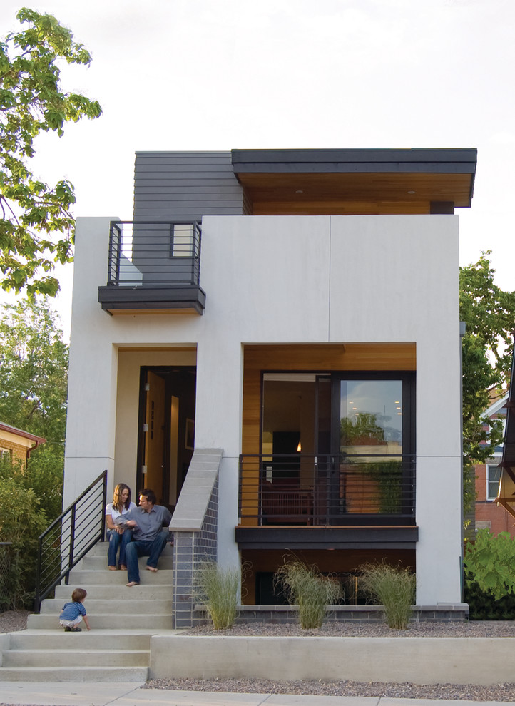 Medium sized and white modern house exterior in Denver with three floors and concrete fibreboard cladding.