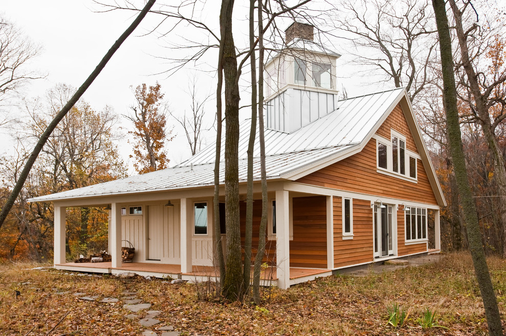 Idee per la villa marrone country a due piani con rivestimento in legno, tetto a capanna e copertura in metallo o lamiera