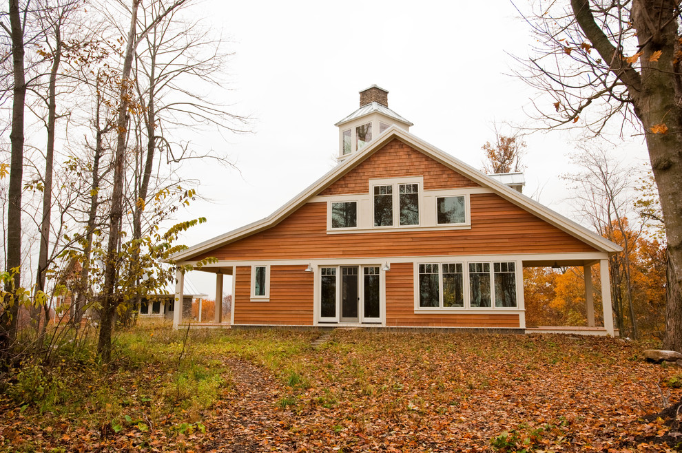 Diseño de fachada de casa marrón campestre de dos plantas con revestimiento de madera, tejado a dos aguas y tejado de metal