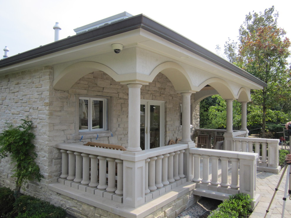 Réalisation d'une façade de maison beige tradition en pierre de taille moyenne et de plain-pied.