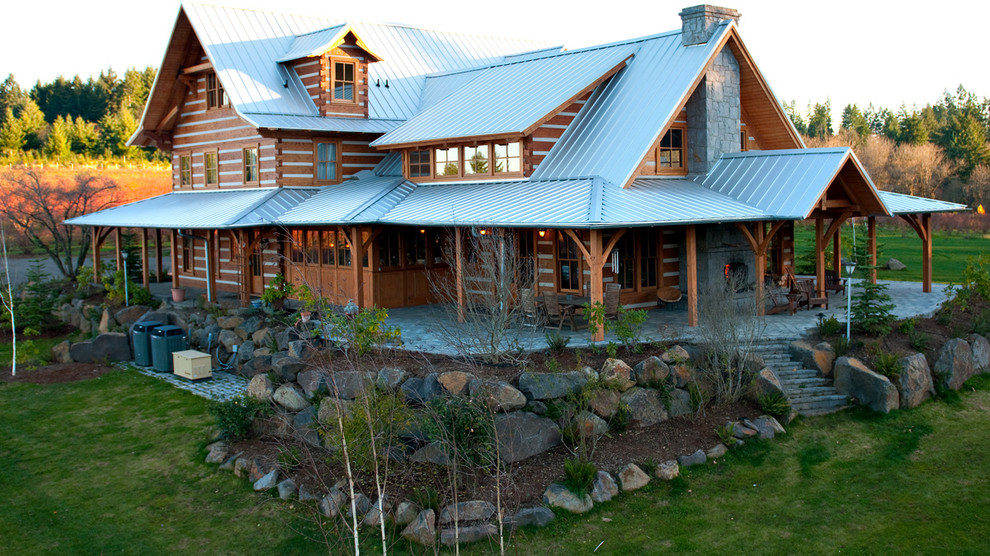 Aménagement d'une grande façade de maison marron montagne en bois à un étage avec un toit à deux pans.