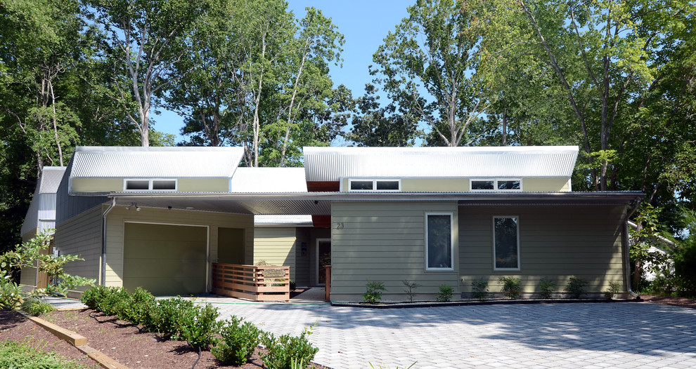 Inspiration pour une façade de maison grise design en panneau de béton fibré de taille moyenne et à un étage avec un toit à deux pans et un toit en métal.