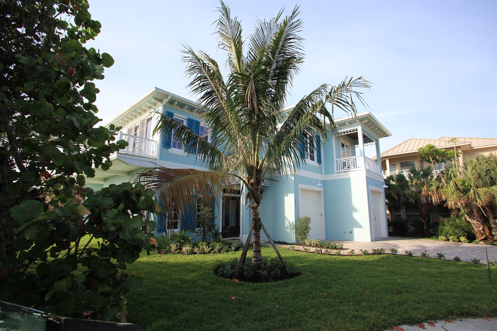 Modelo de fachada de casa azul marinera grande de dos plantas con revestimiento de estuco