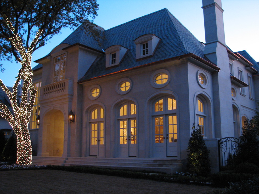 Foto della villa ampia beige classica a tre piani con rivestimento in pietra, tetto a capanna e copertura a scandole