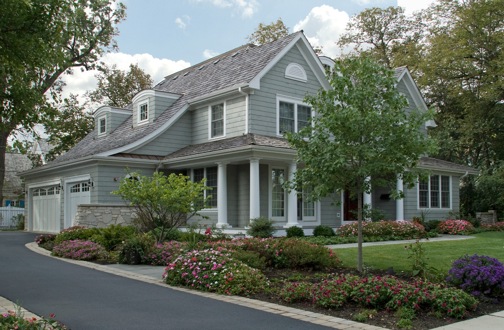 На фото: двухэтажный, серый дом среднего размера в классическом стиле с облицовкой из винила и двускатной крышей