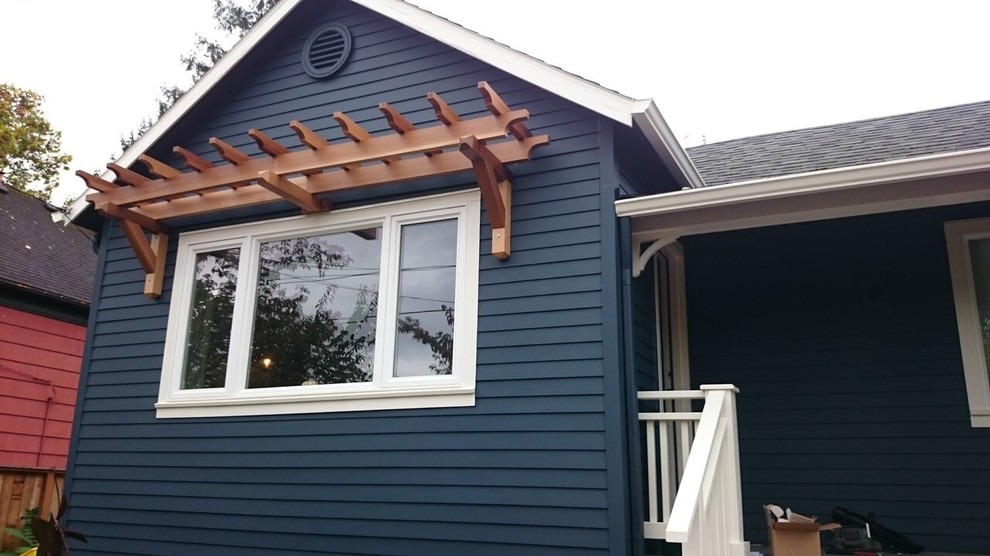 Ejemplo de fachada de casa azul contemporánea de tamaño medio de dos plantas con tejado a dos aguas y tejado de teja de madera
