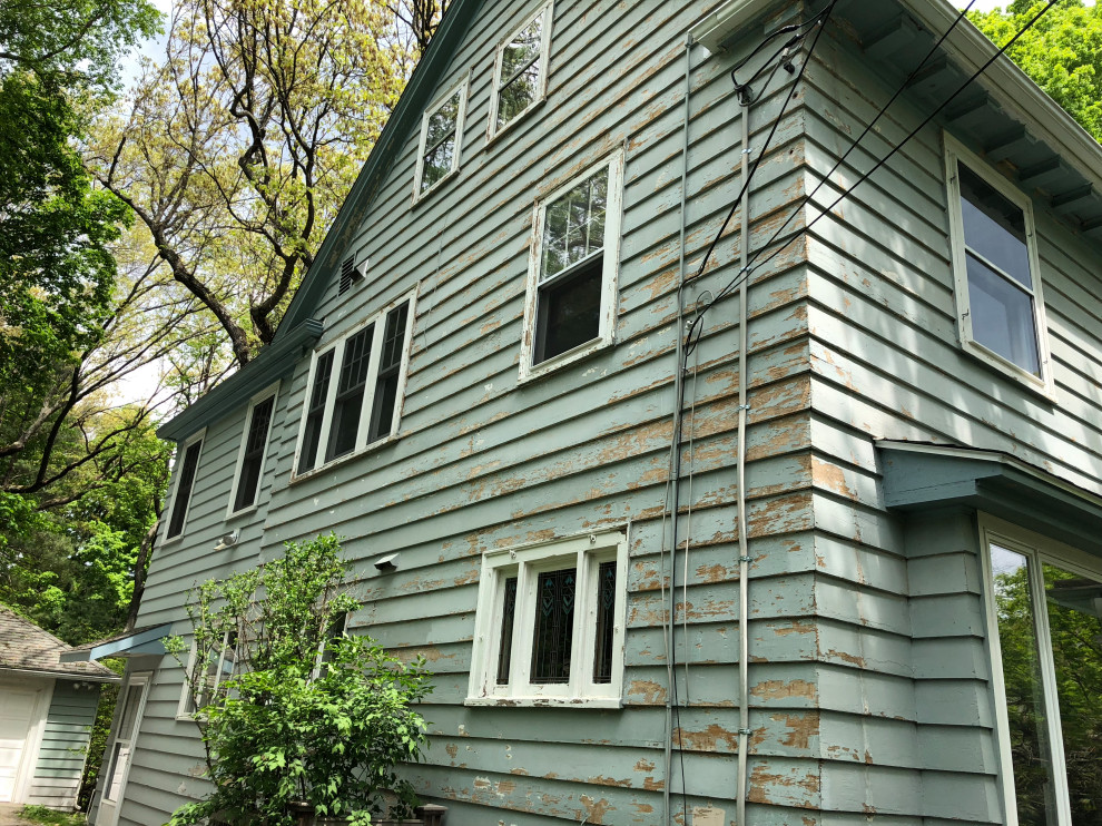 Ejemplo de fachada de casa azul vintage grande de dos plantas con revestimiento de madera, tejado a dos aguas y tejado de teja de madera