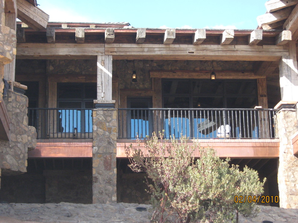 Cette image montre une très grande façade de maison marron vintage à un étage avec un revêtement mixte et un toit à deux pans.