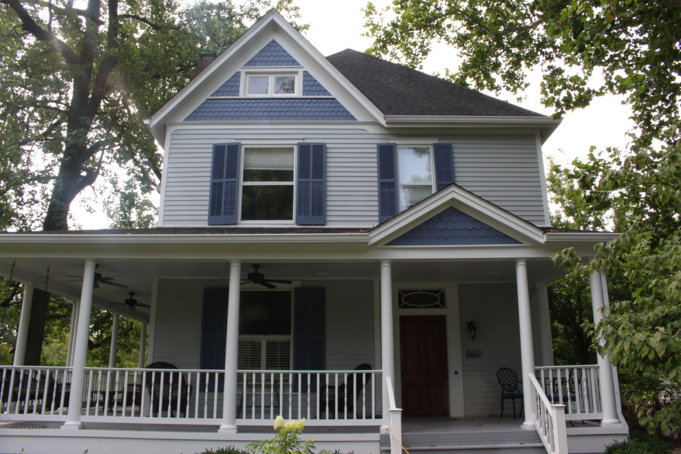 Стильный дизайн: двухэтажный, синий частный загородный дом среднего размера в викторианском стиле с облицовкой из ЦСП, двускатной крышей и крышей из гибкой черепицы - последний тренд
