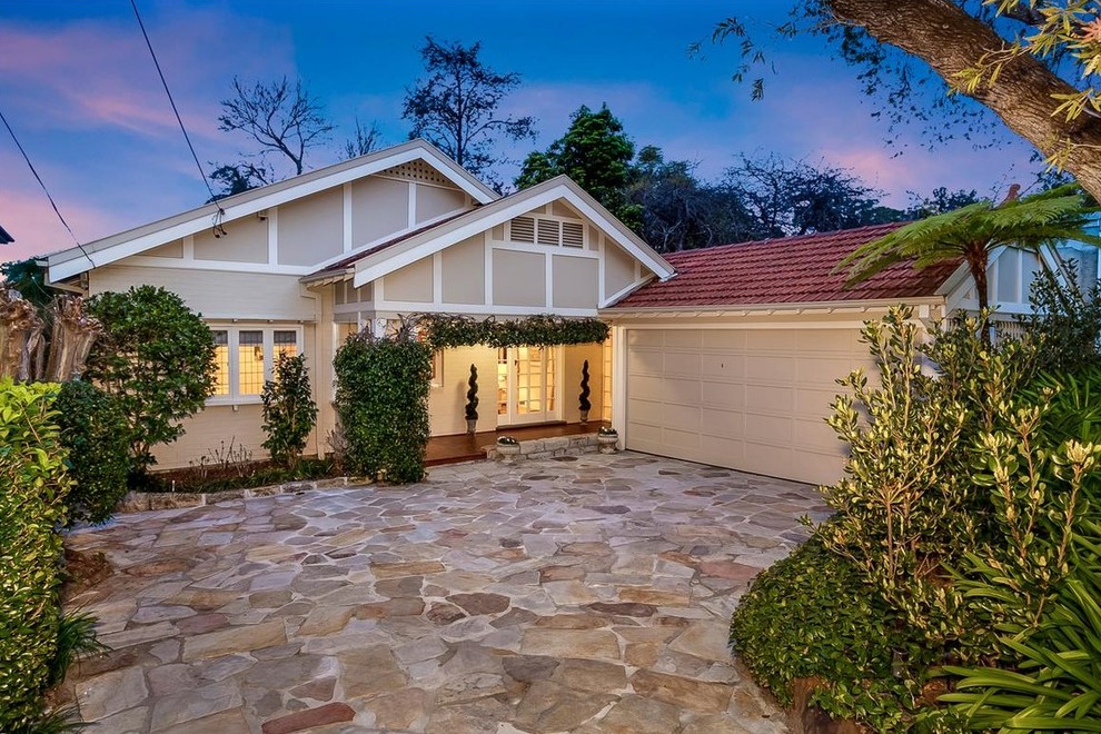 Photo of a medium sized and white traditional bungalow brick house exterior in Sydney with a pitched roof.